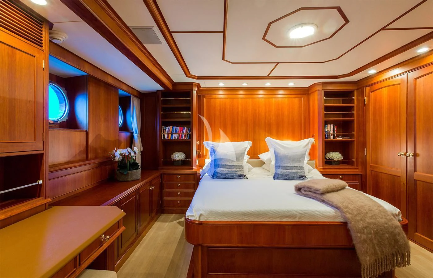 a bedroom with a bed and a bookcase aboard PIONEER Yacht for Sale