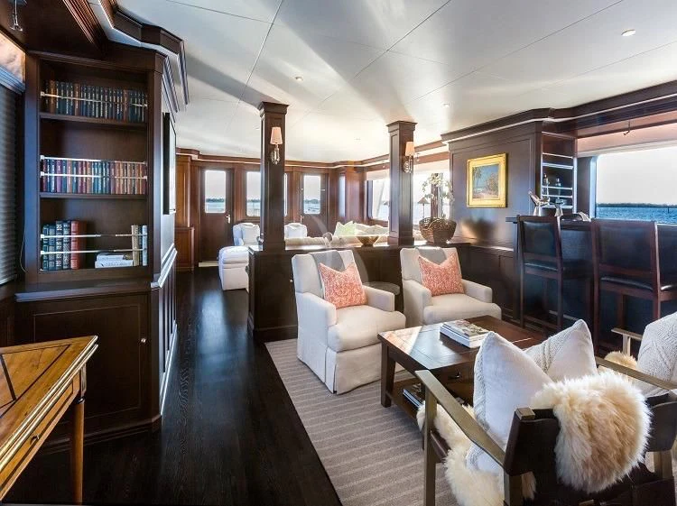 a living room with a large bookcase aboard PIONEER Yacht for Sale