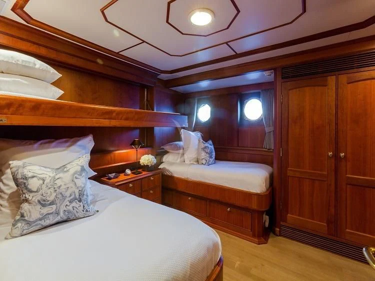 a room with a bed and a dresser aboard PIONEER Yacht for Sale