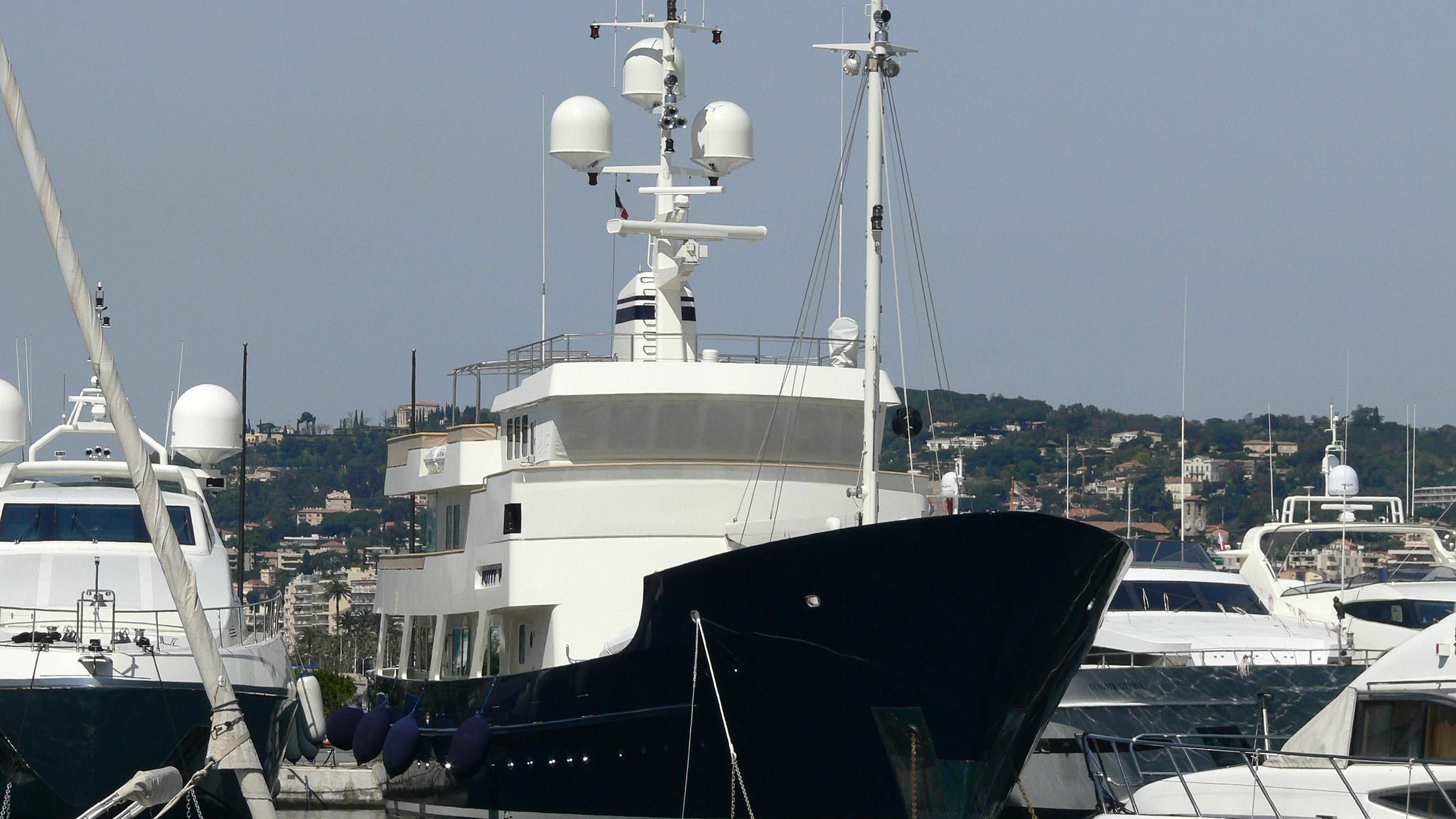 a large white boat sits in a harbor aboard PIONEER Yacht for Sale