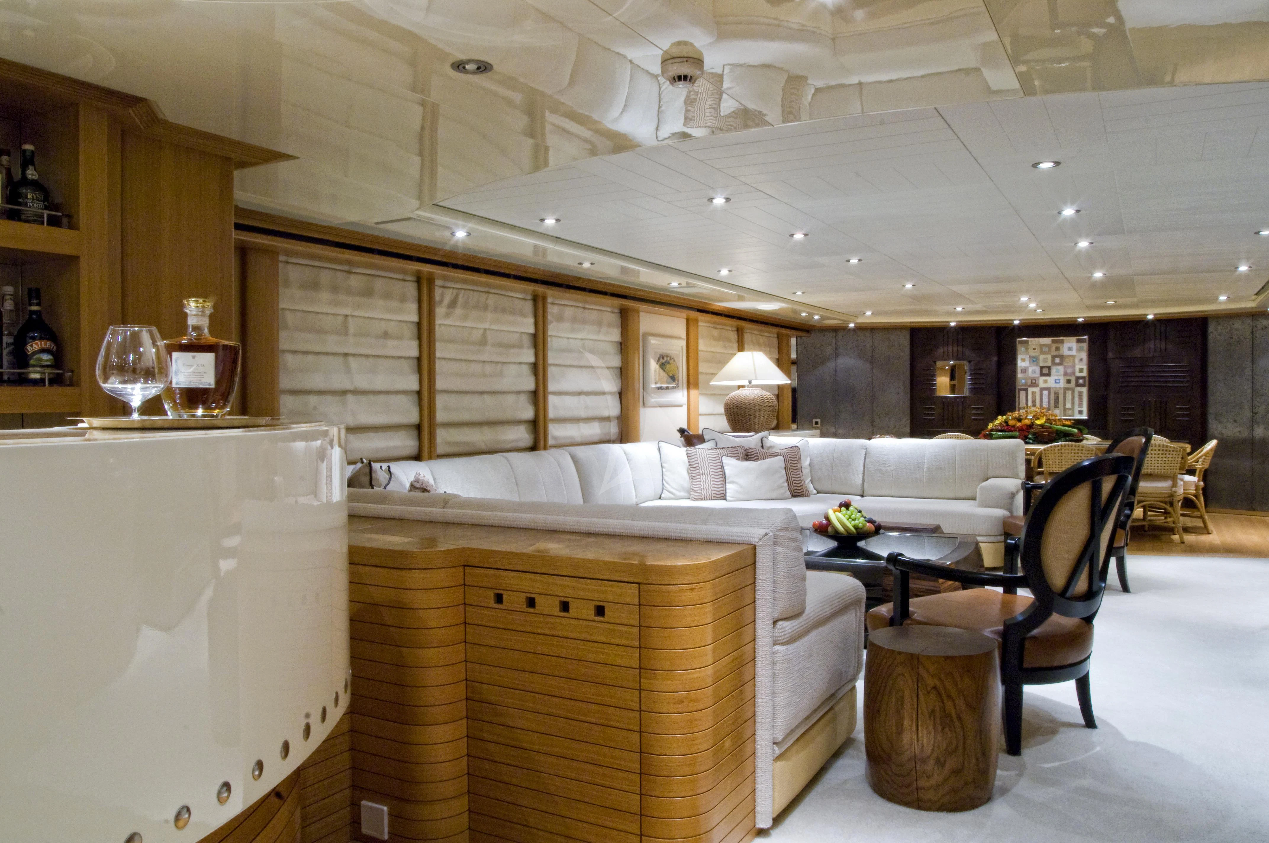 a large living room with a large white couch and a large white table aboard KIJO Yacht for Sale