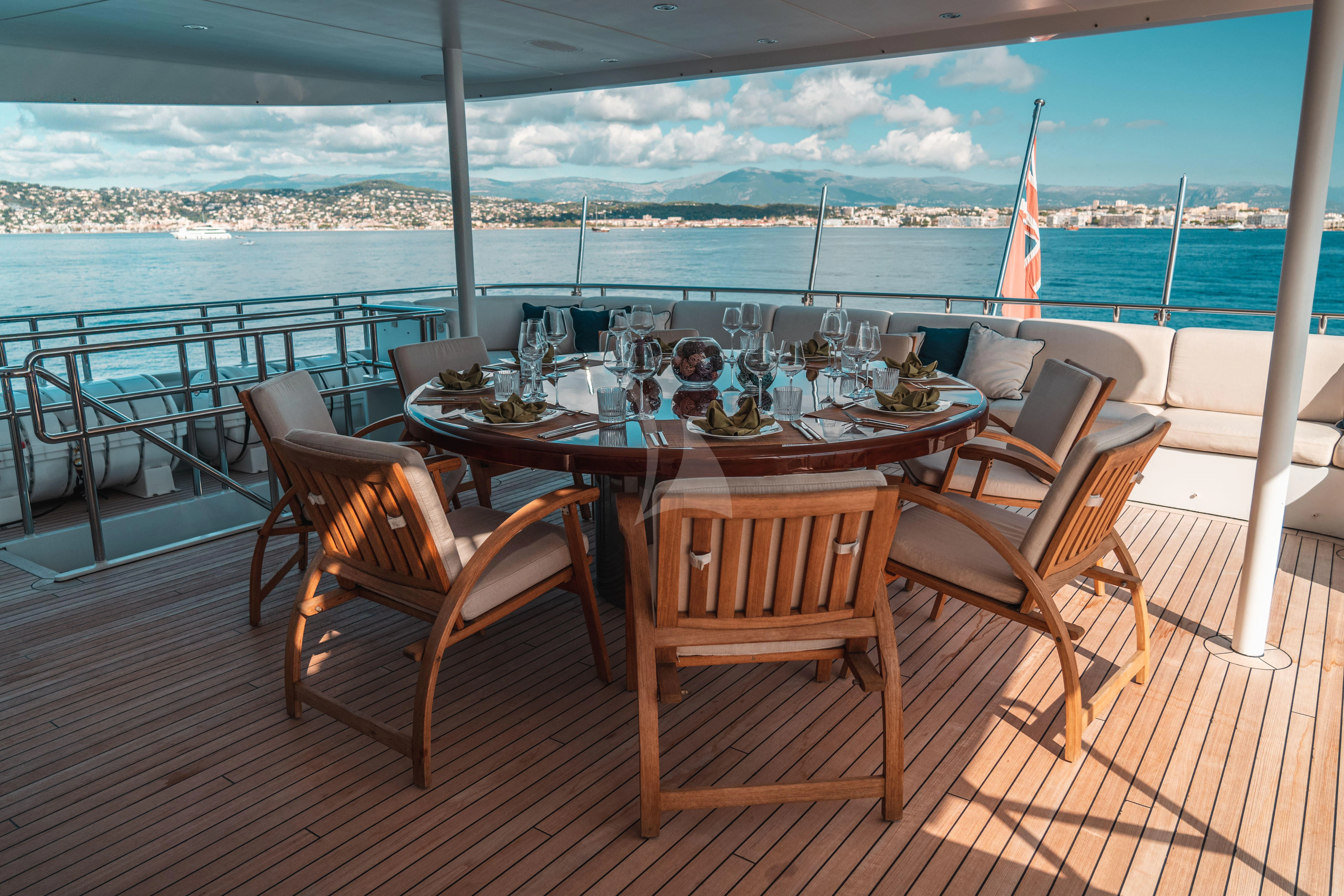 a table set for a meal on a deck overlooking a body of water aboard KIJO Yacht for Sale
