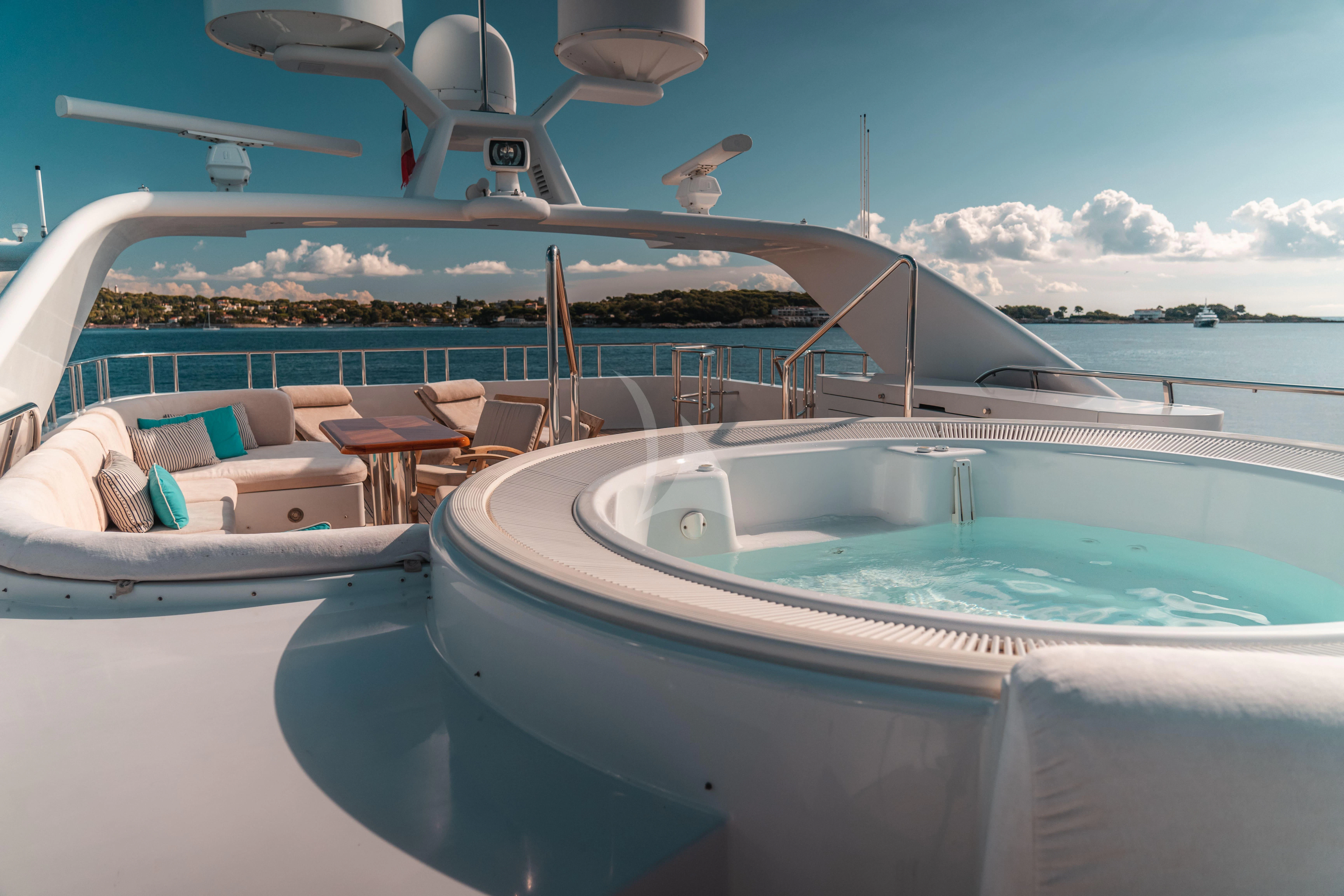 a pool with chairs and a table on the deck aboard KIJO Yacht for Sale
