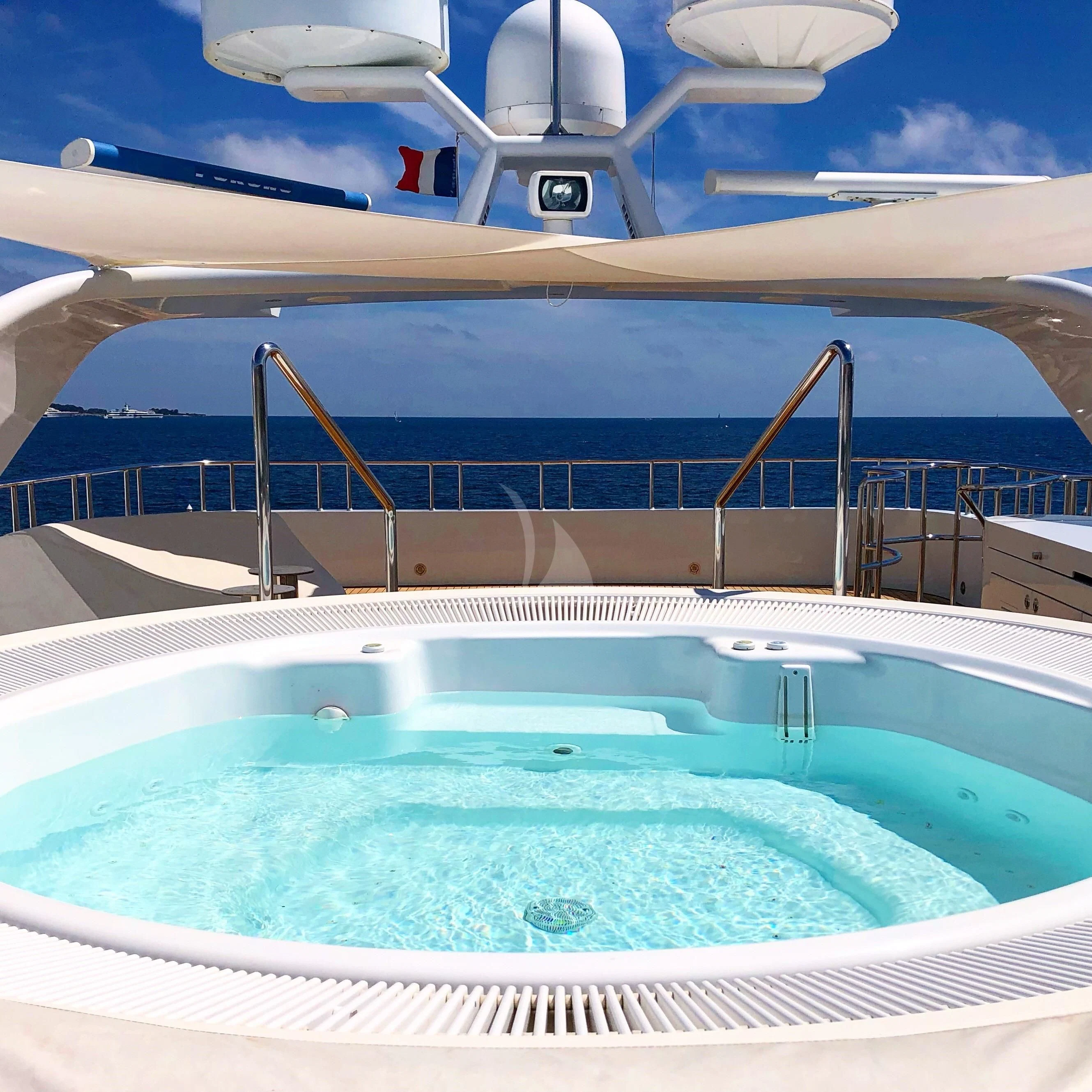 a swimming pool with a large blue pool and a white wall aboard KIJO Yacht for Sale