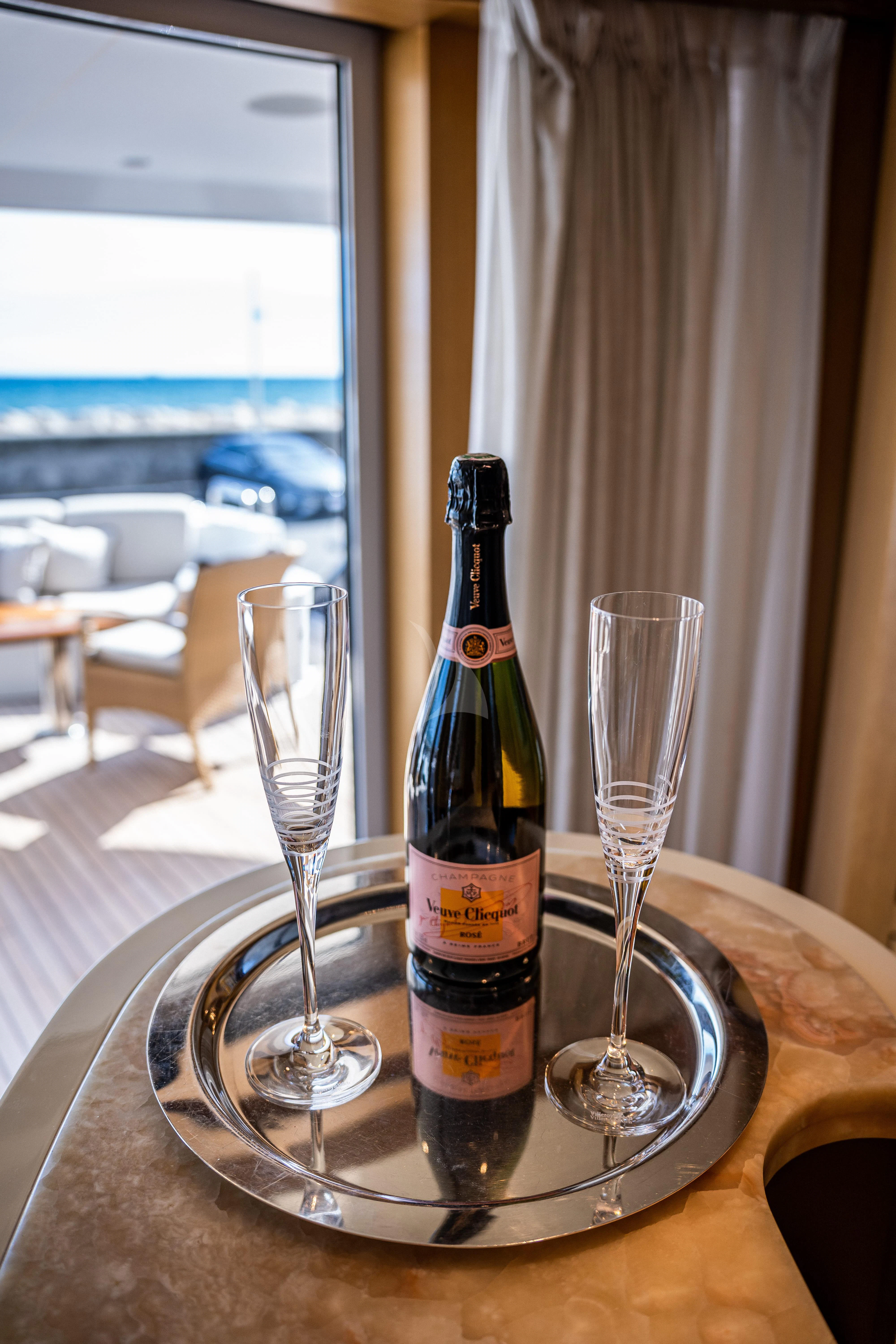a bottle of wine and a glass on a table aboard KIJO Yacht for Sale