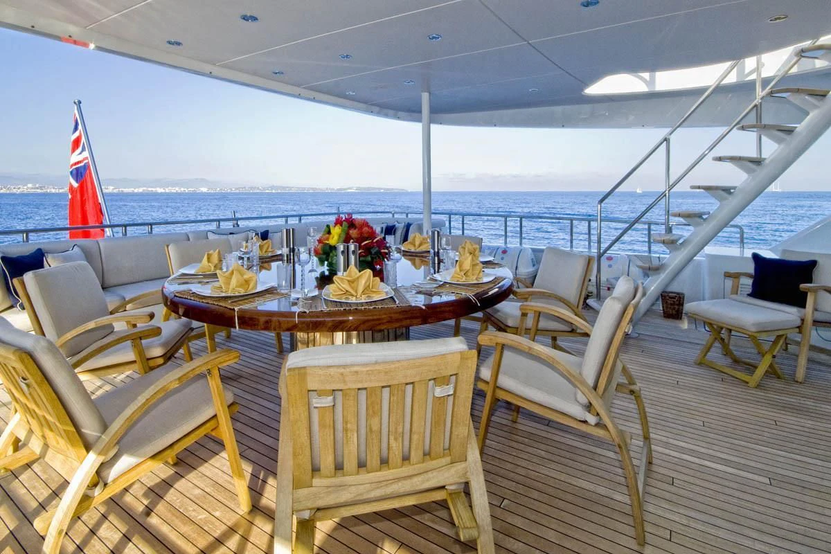 a table with chairs on a deck overlooking the ocean aboard KIJO Yacht for Sale