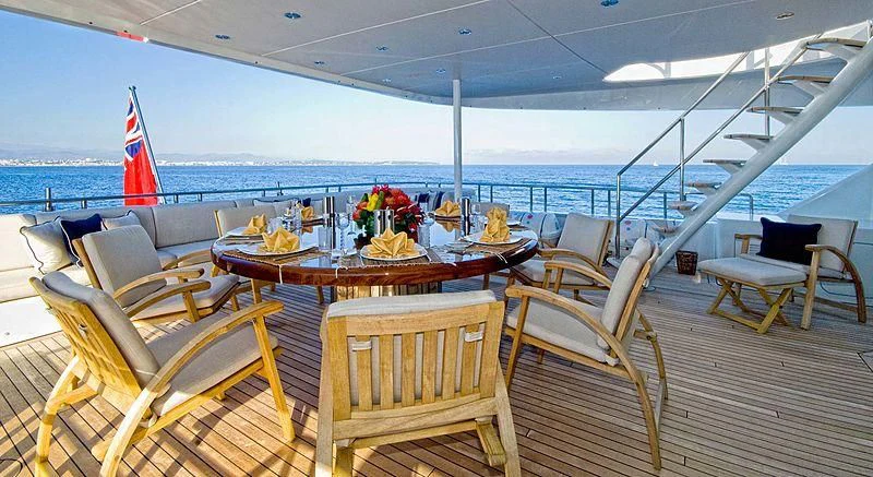 a table with chairs and a view of the ocean aboard KIJO Yacht for Sale