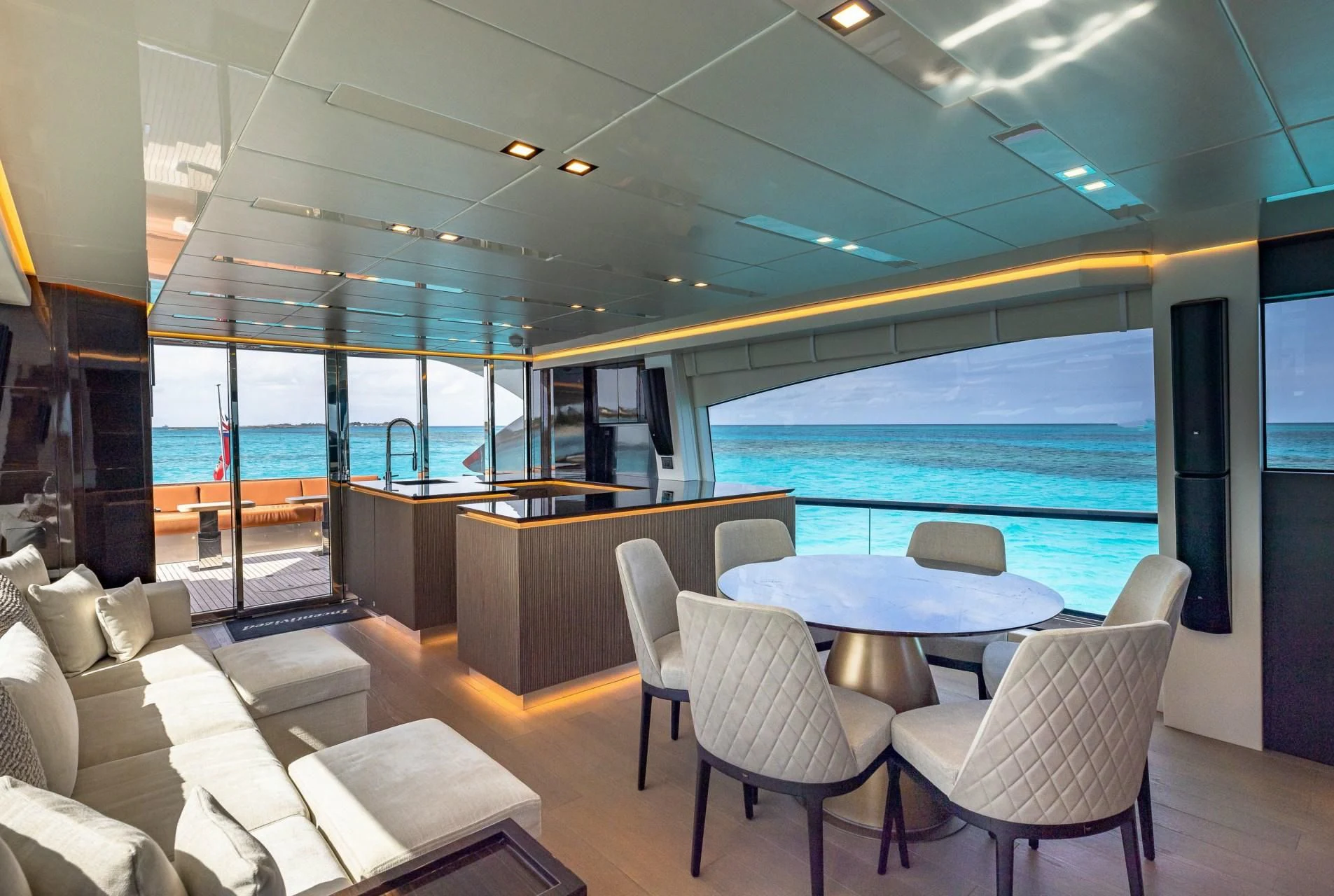 a room with a table chairs and a large blue glass window aboard INCENTIVIZED Yacht for Sale