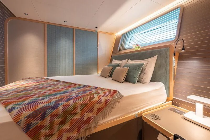 a bed with a colorful comforter aboard KIA ORA Yacht for Sale