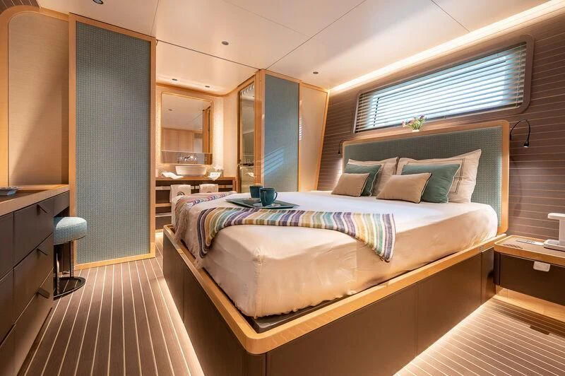 a bedroom with a bed and a desk aboard KIA ORA Yacht for Sale