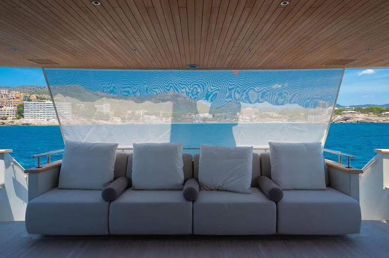 a couch and a window overlooking a body of water aboard KIA ORA Yacht for Sale