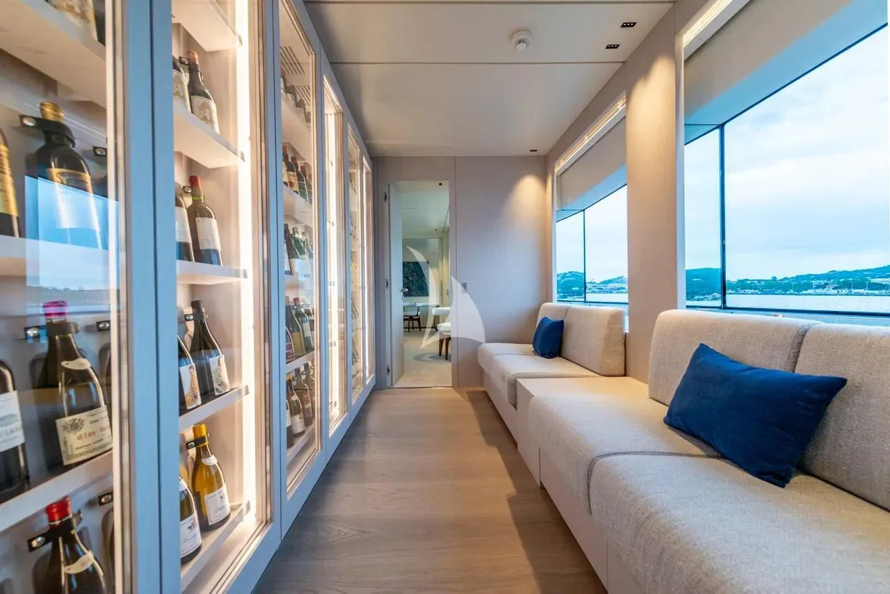 a room with a couch and a shelf with bottles on it aboard ARSANA Yacht for Charter