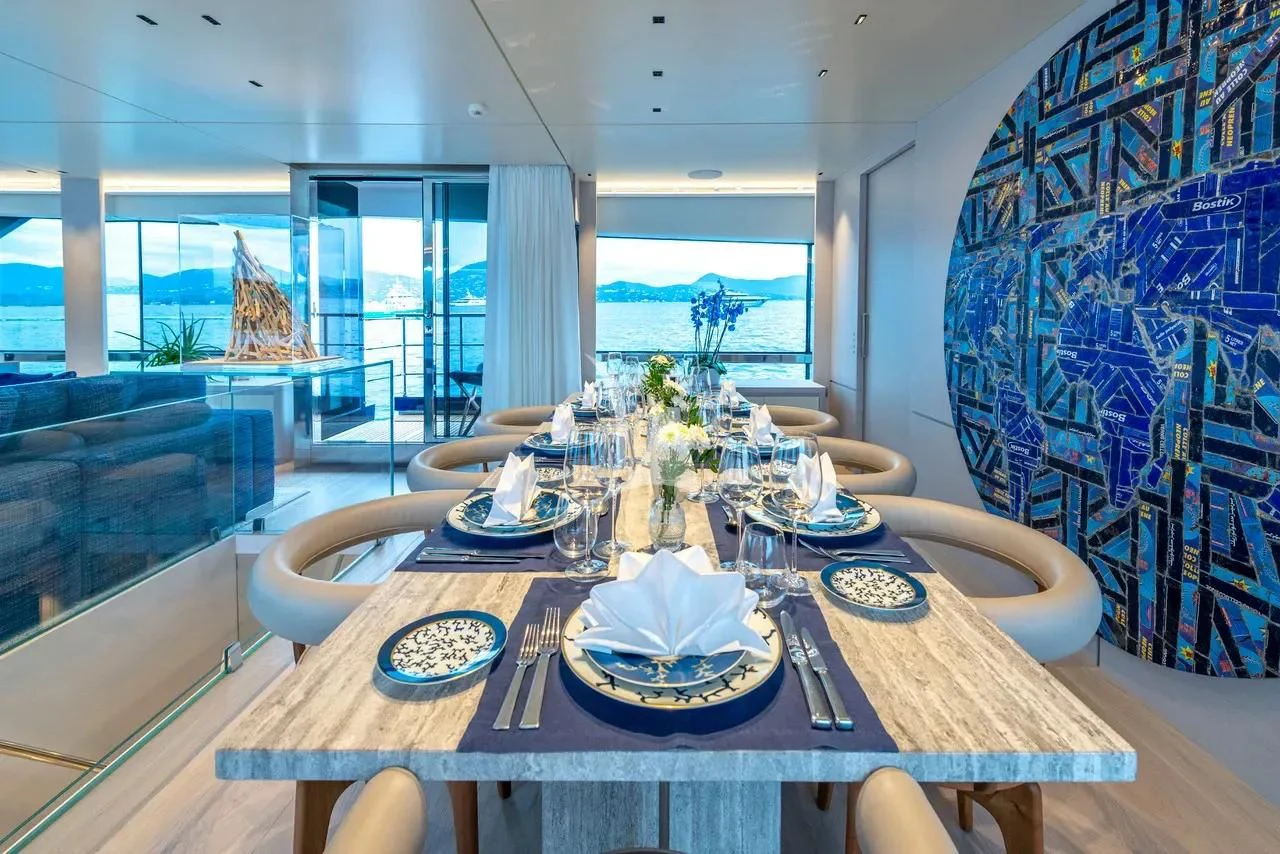 a dining table with plates and flowers aboard ARSANA Yacht for Charter