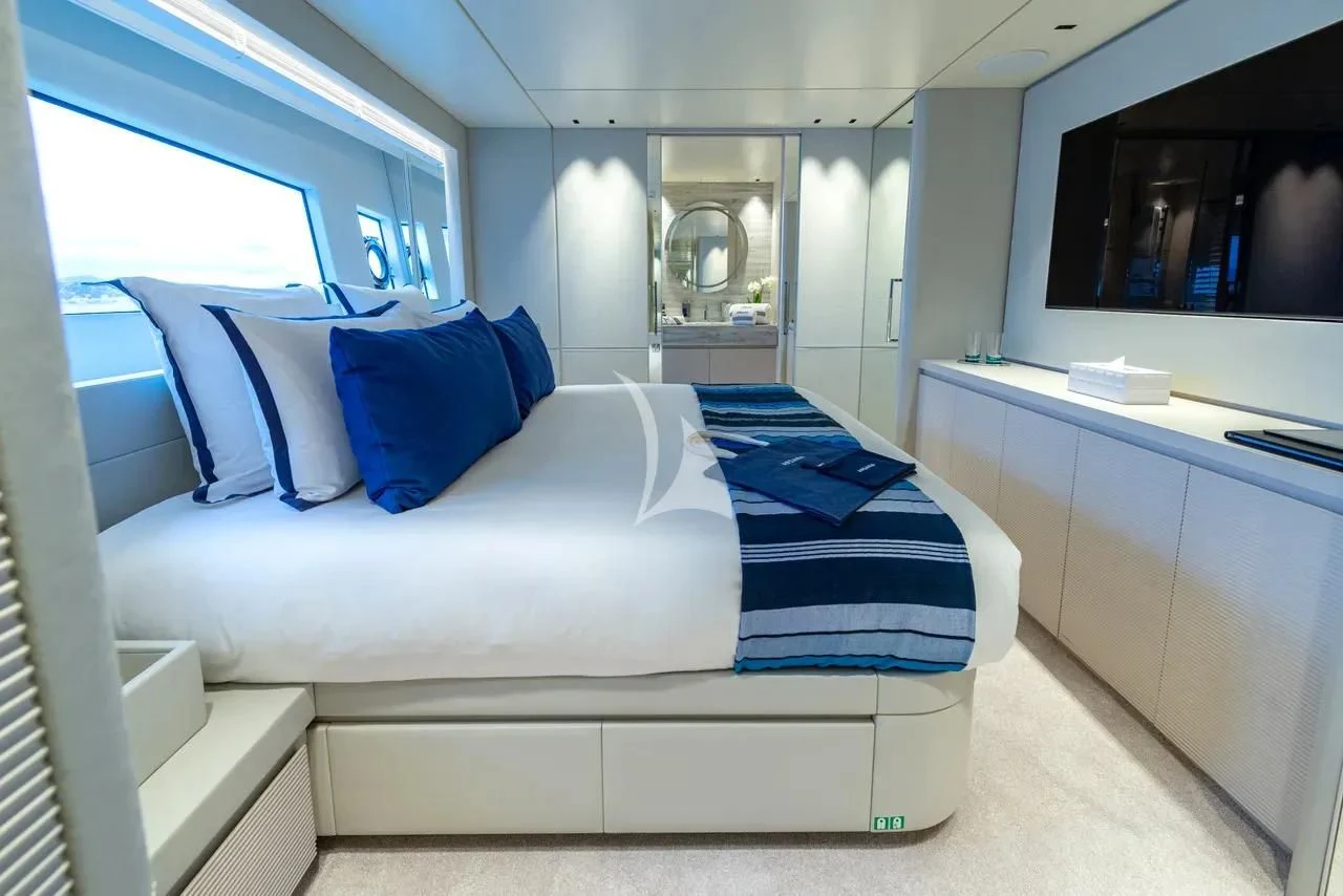 a white bed with blue pillows aboard ARSANA Yacht for Charter