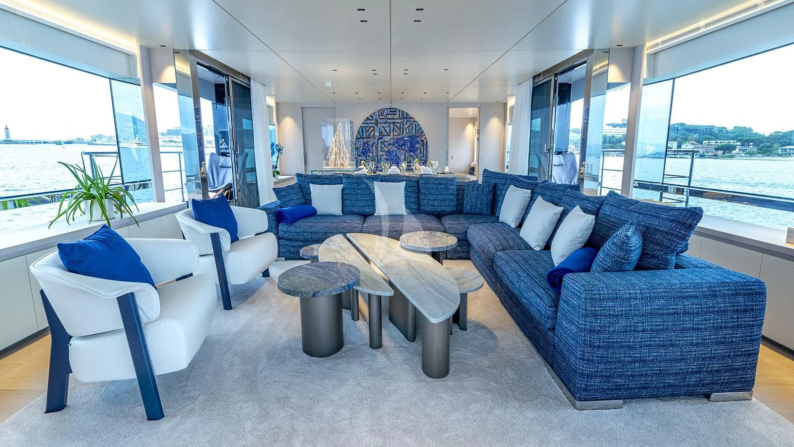 a room with blue couches and a large window aboard ARSANA Yacht for Charter