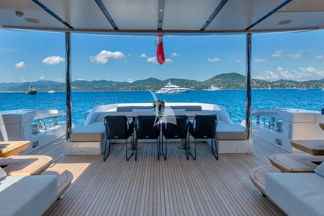 a deck with chairs and tables on it by the ocean aboard ARSANA Yacht for Charter