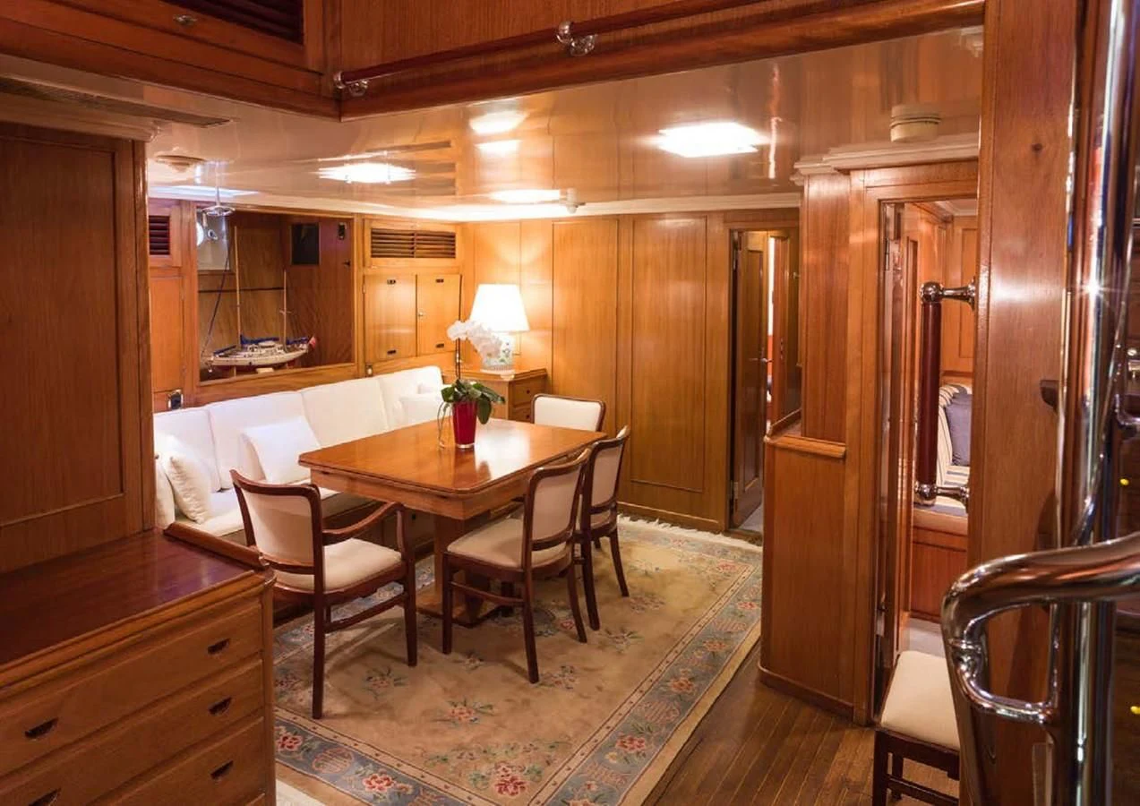 a room with a table chairs and a couch aboard FEI-SEEN Yacht for Sale