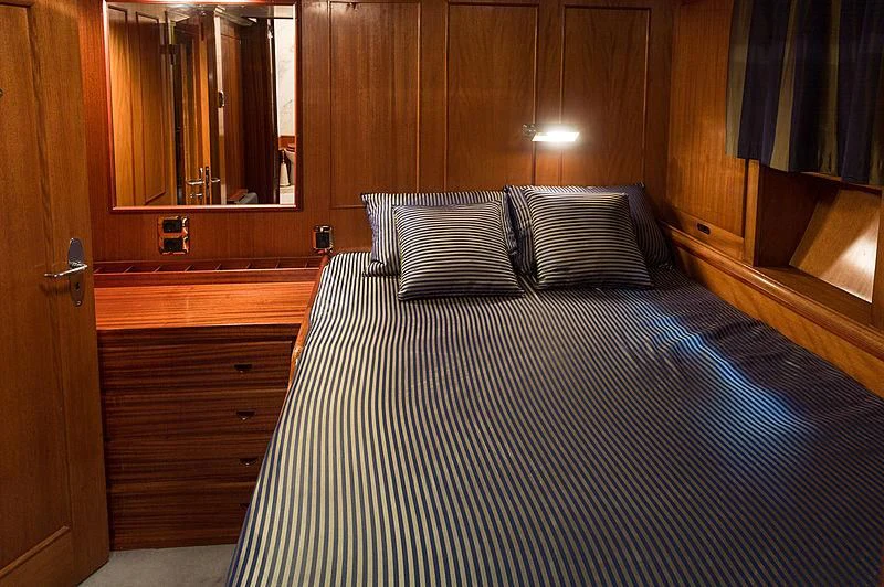 a bed with a blue and white checkered blanket aboard FEI-SEEN Yacht for Sale