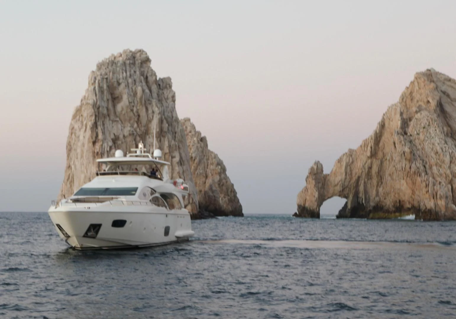 a boat in the water with Arch of Cabo San Lucas in the background aboard ANDREIKA Yacht for Sale