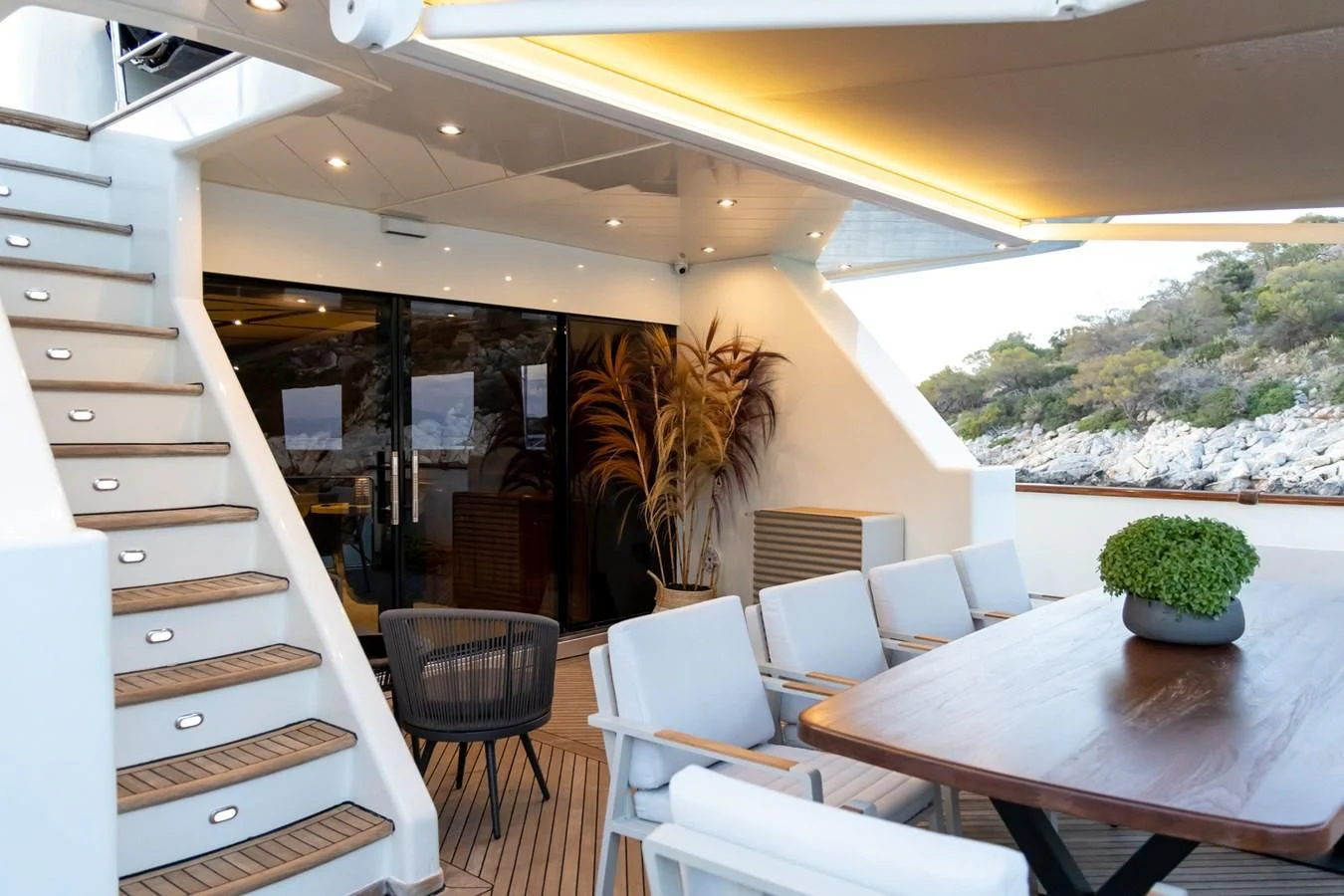 a room with a table chairs and plants aboard AQUILLA Yacht for Sale