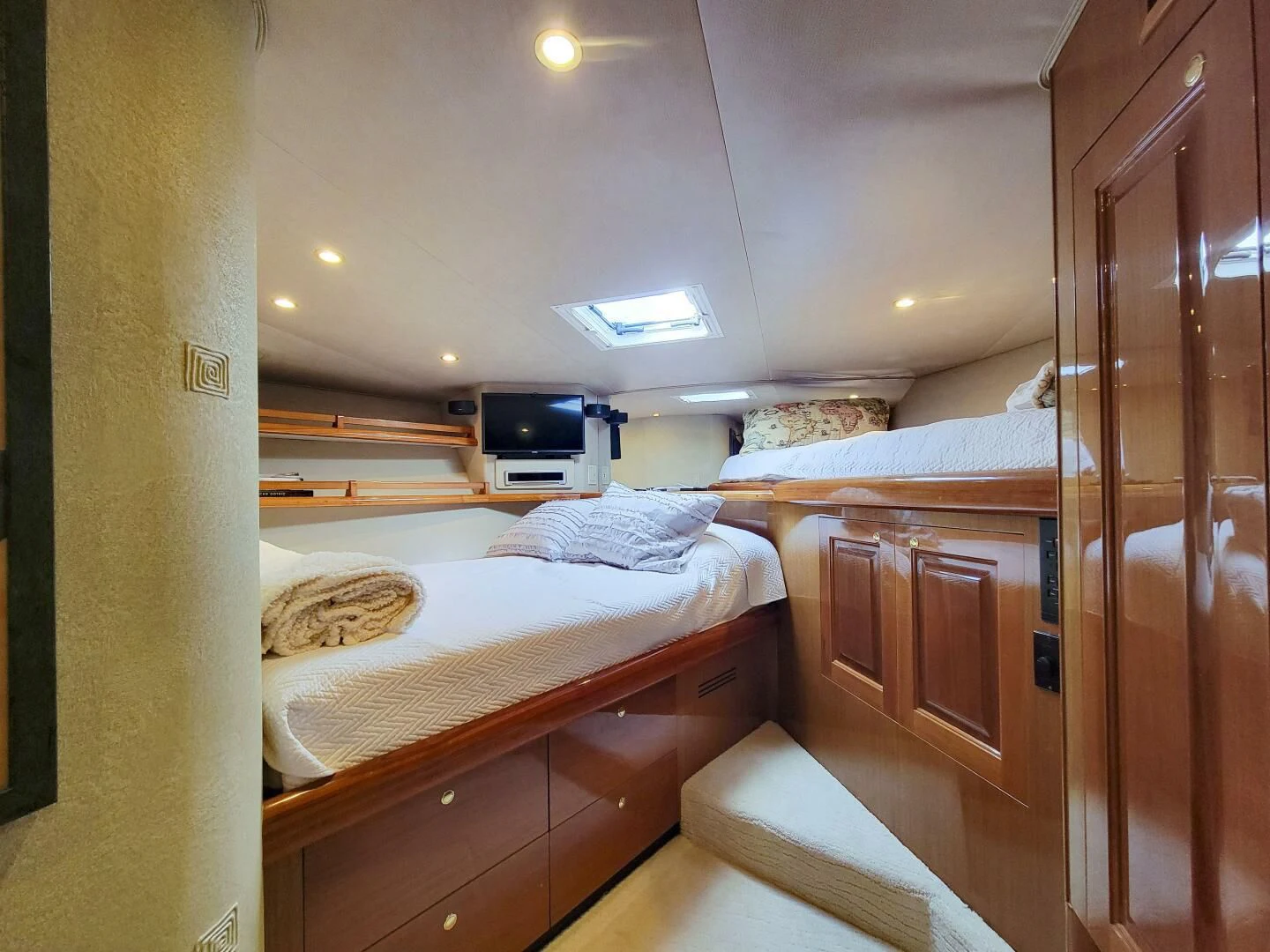 a bedroom with a bed and a television aboard PRIME TIME Yacht for Sale