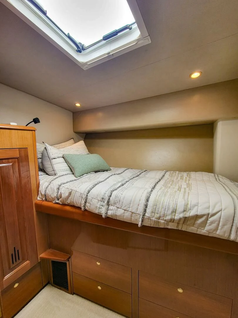 a bed with a white comforter aboard PRIME TIME Yacht for Sale