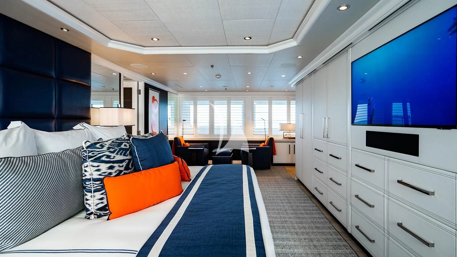 a bedroom with a large blue and white rug and a large blue and orange rug aboard ALTA Yacht for Sale