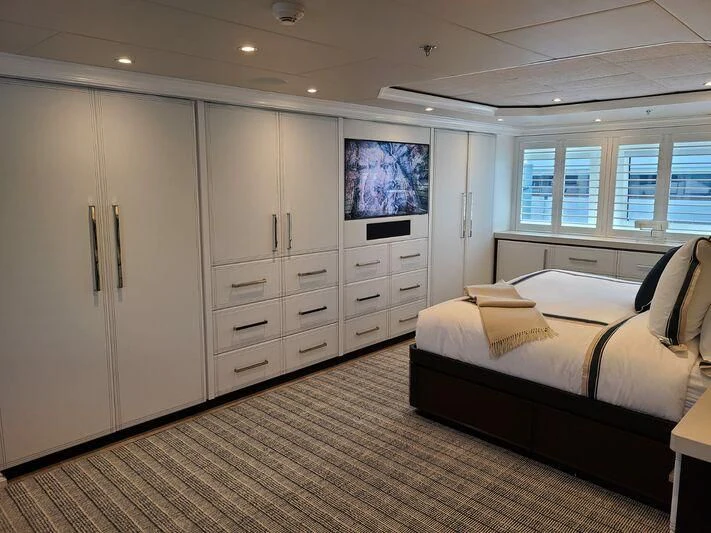 a bedroom with a bed and cabinets aboard ALTA Yacht for Sale