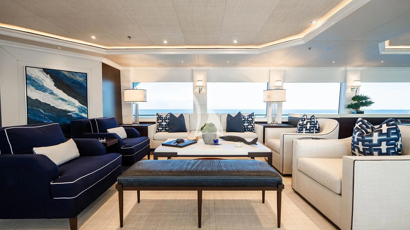 a living room with a large blue couch and a coffee table aboard ALTA Yacht for Sale