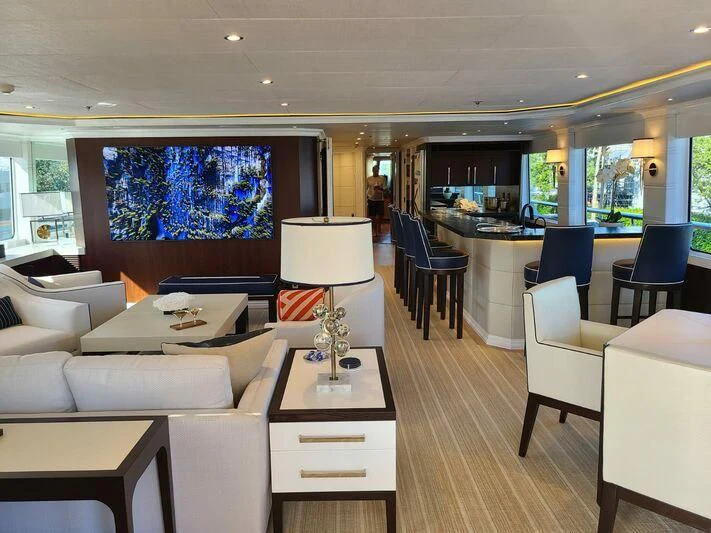 a room with a table chairs and a lamp aboard ALTA Yacht for Sale