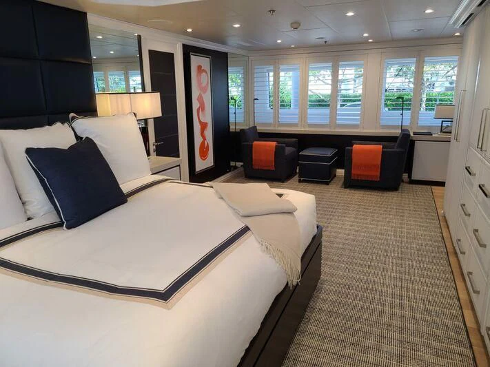 a large hotel room with a large bed and a chair aboard ALTA Yacht for Sale