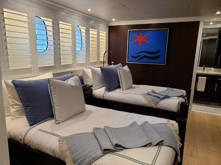 a bed with blue pillows aboard ALTA Yacht for Sale