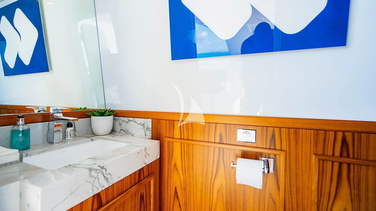 a bathroom with a countertop sink and a painting on the wall aboard ALTA Yacht for Sale