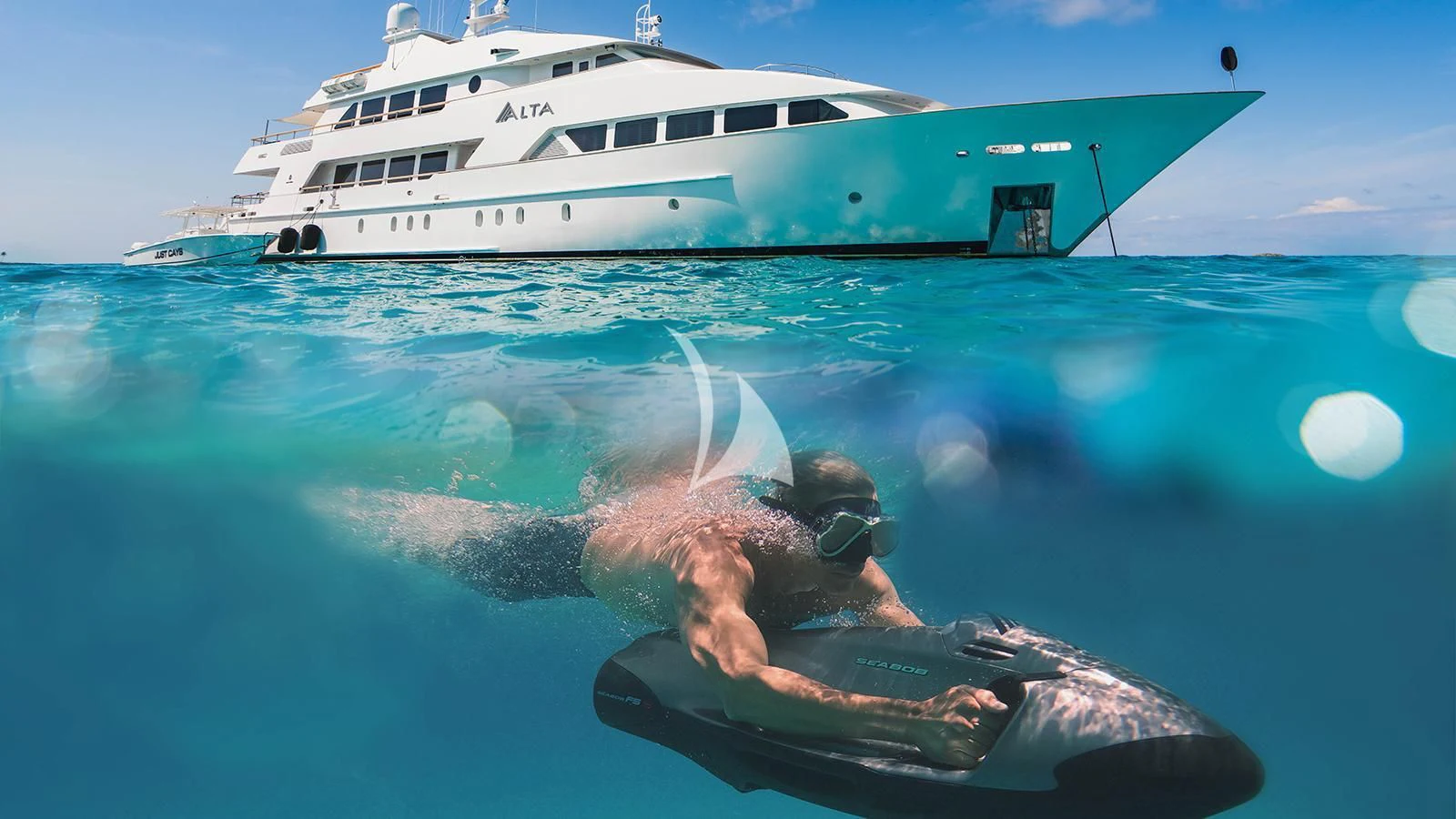 a man swimming in a pool with a boat in the background aboard ALTA Yacht for Sale