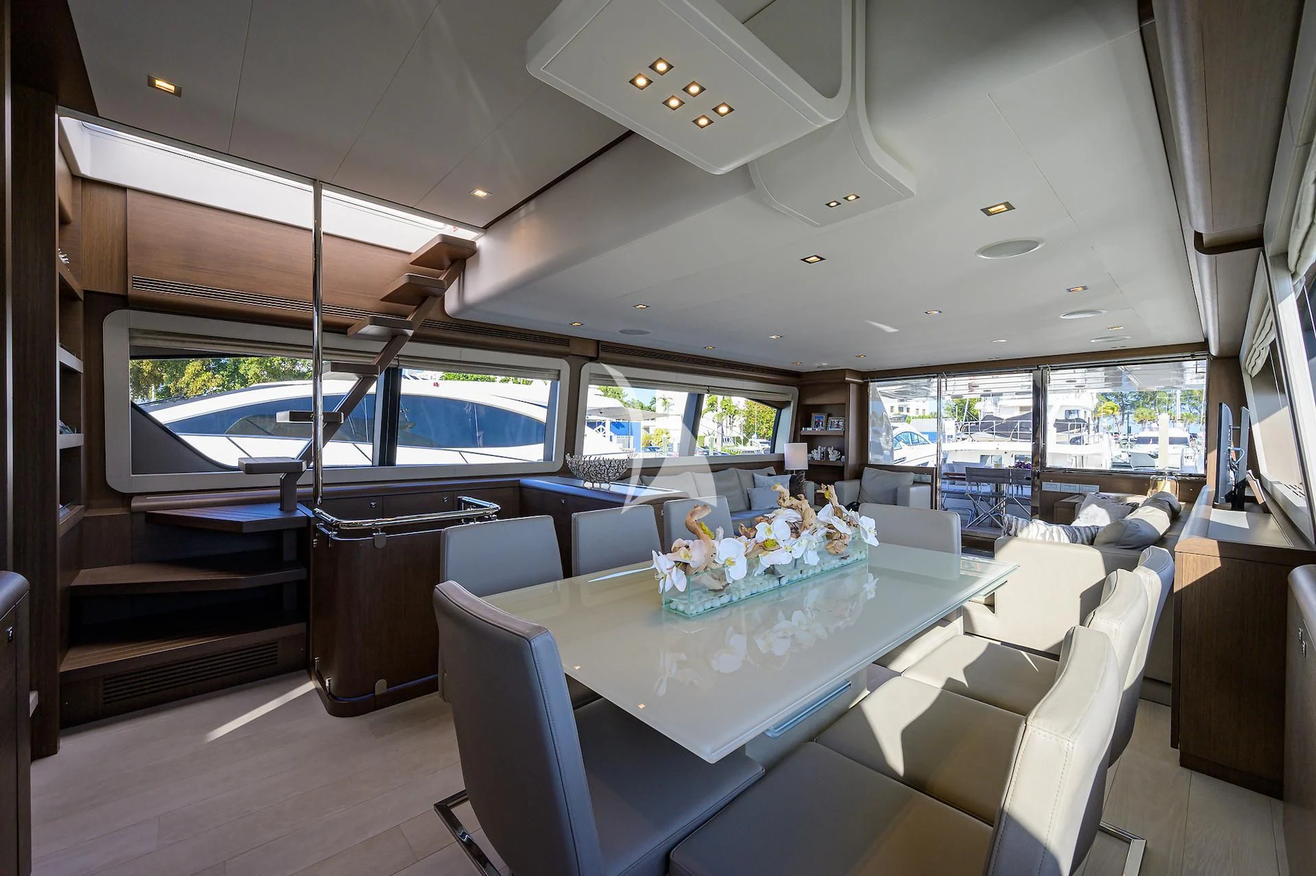 a large room with a table and chairs and a large window aboard LEON Yacht for Sale