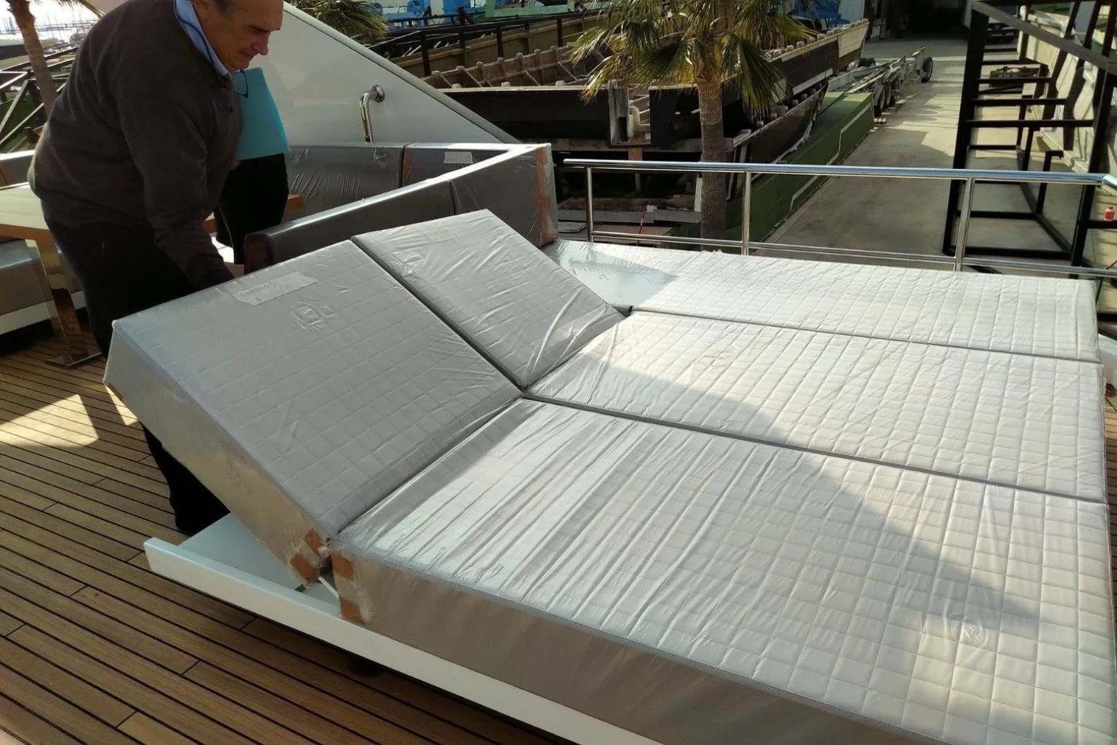 a man working on a large white sheet aboard SERENITY Yacht for Sale