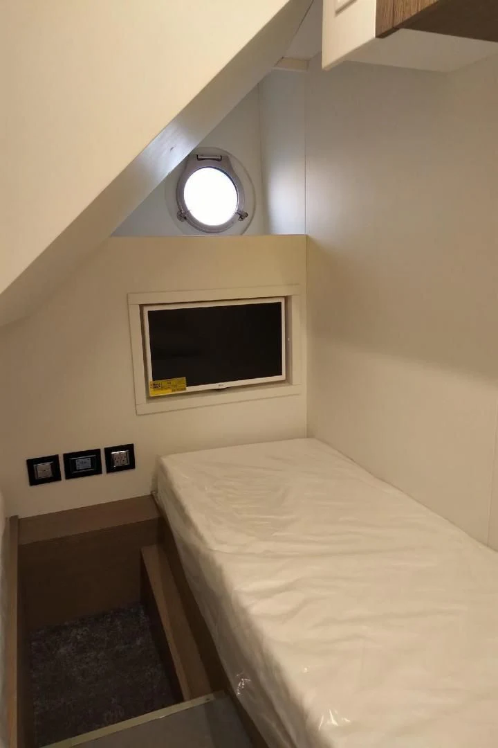 a bed with a round mirror above it aboard SERENITY Yacht for Sale