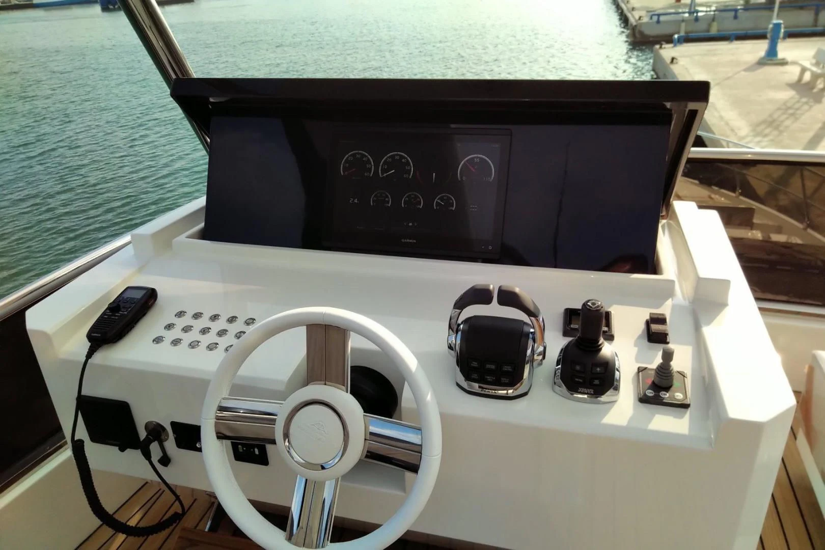 a white gaming console with a black controller and a black cable aboard SERENITY Yacht for Sale