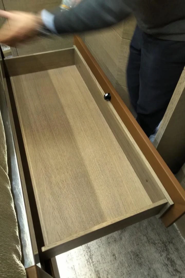 a wooden table with a person's legs and a wood surface aboard SERENITY Yacht for Sale