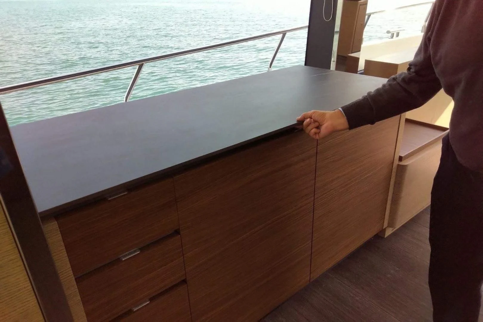 a person standing next to a railing aboard SERENITY Yacht for Sale