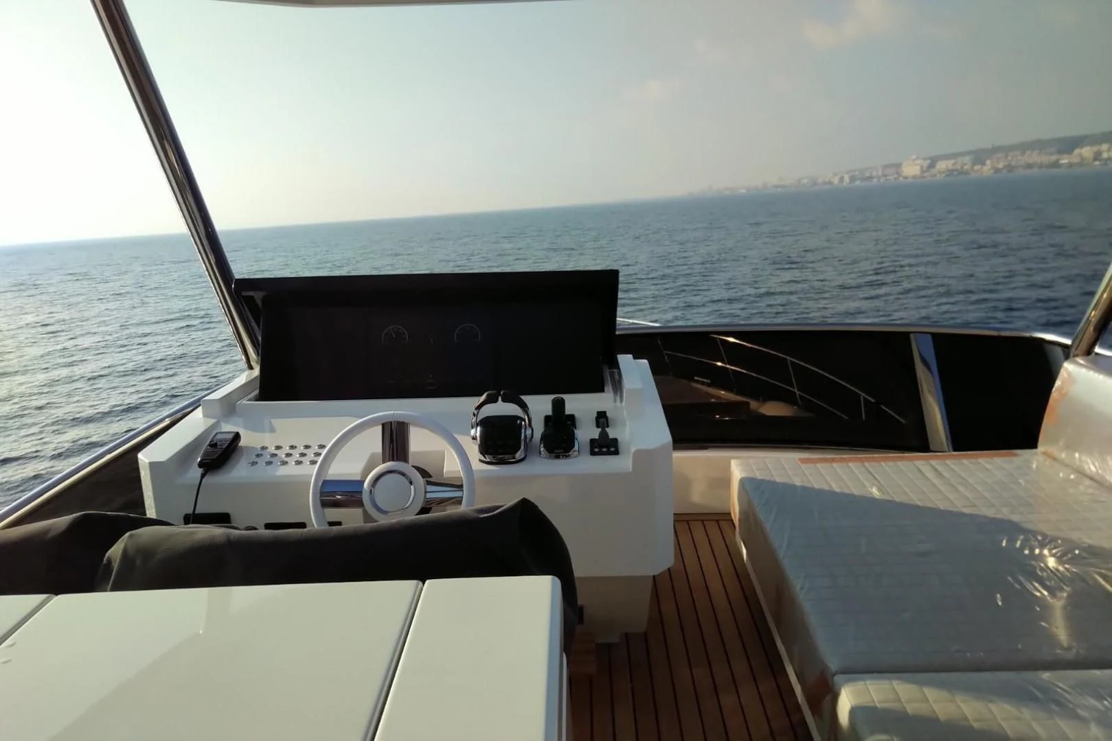 a boat with a steering wheel and a boat in the background aboard SERENITY Yacht for Sale