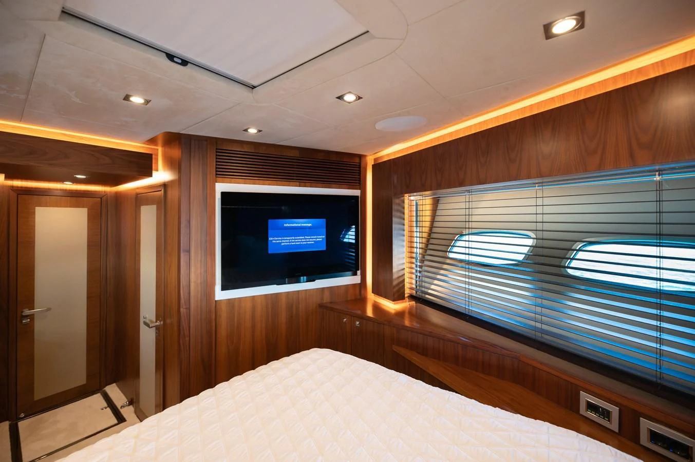 a room with a bed and a television aboard BLADE 6 Yacht for Charter
