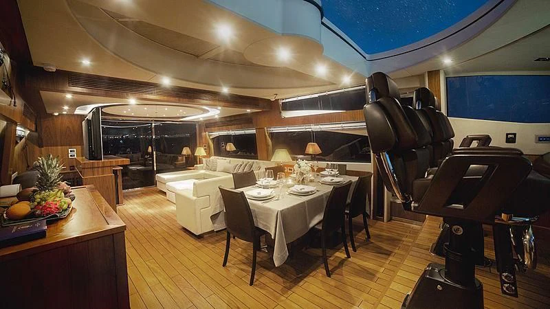 a large room with a piano and a table and chairs aboard BLADE 6 Yacht for Charter