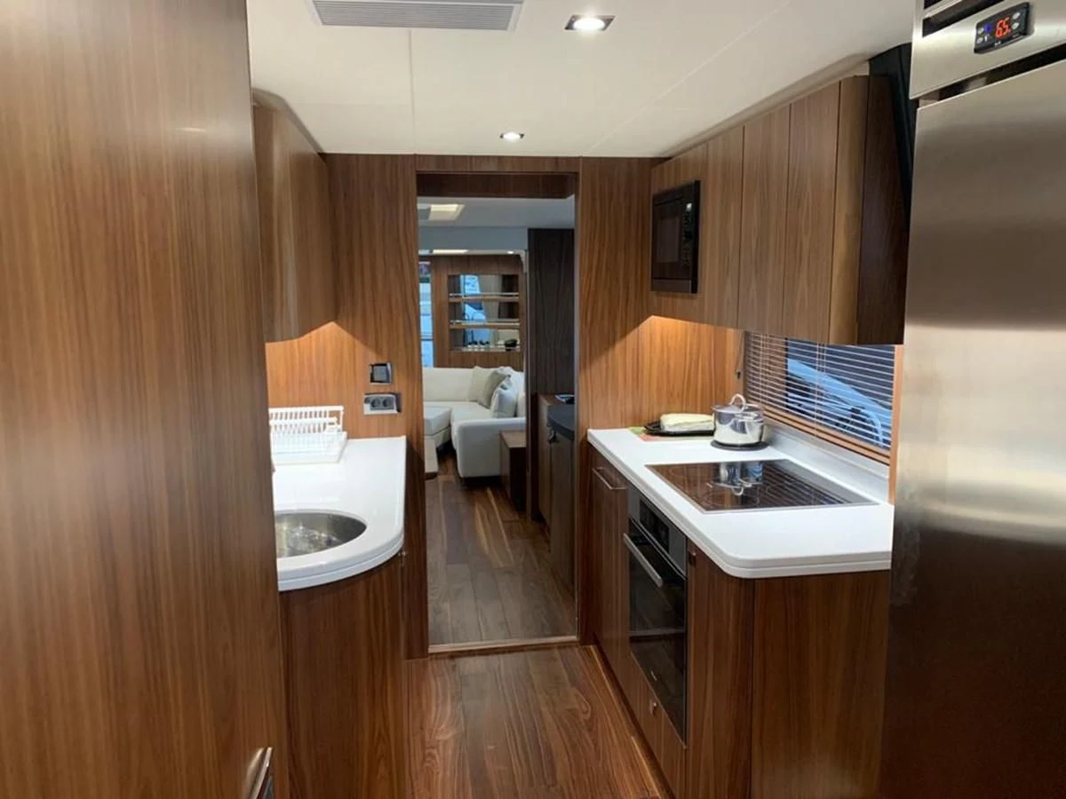 a kitchen with wooden cabinets aboard SUNSEEKER 86 Yacht for Sale