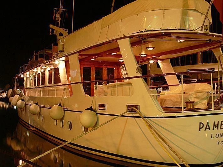 a white boat in a harbor aboard PAMELA IV Yacht for Sale