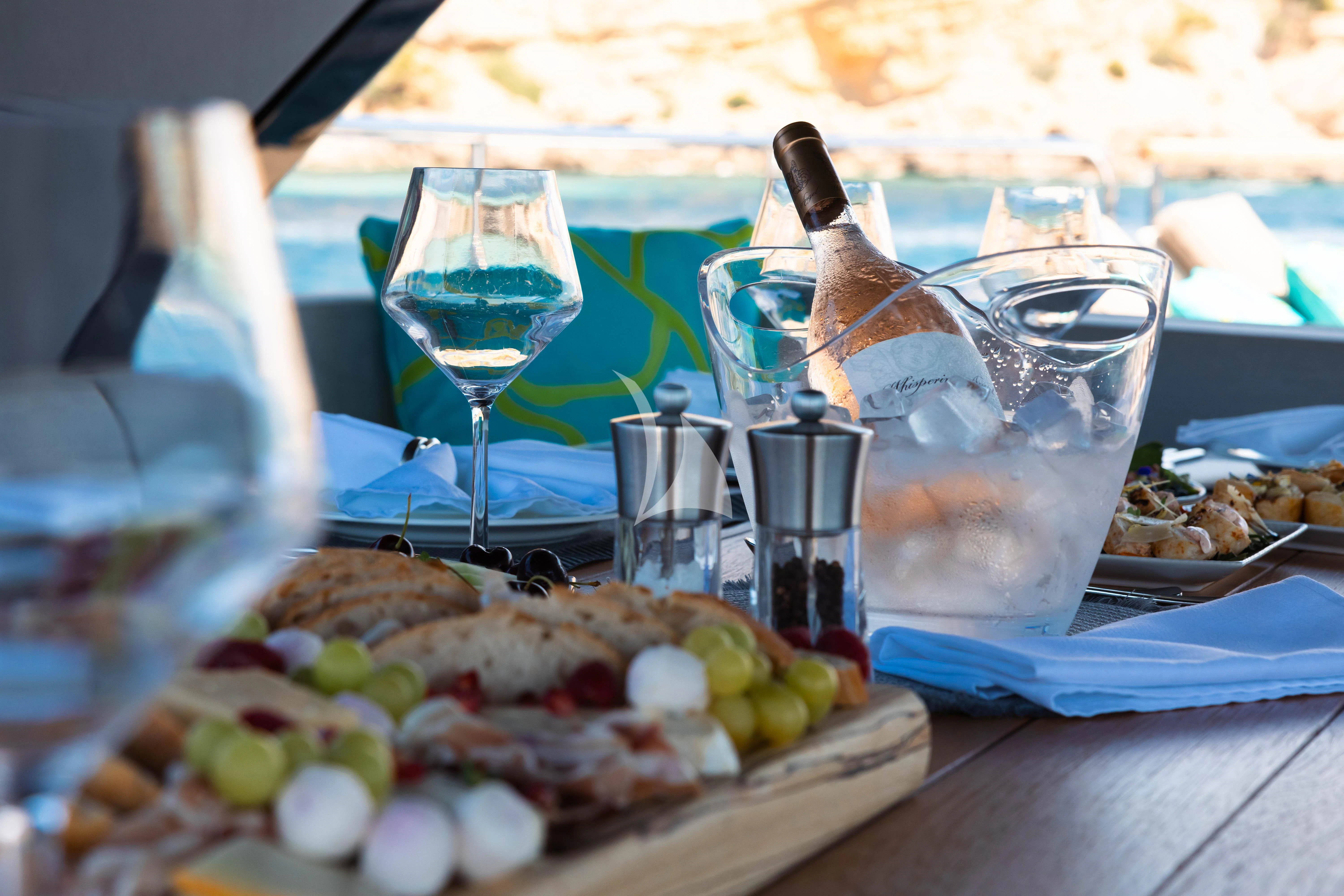 a table with food and glasses aboard MOONLIGHT Yacht for Sale