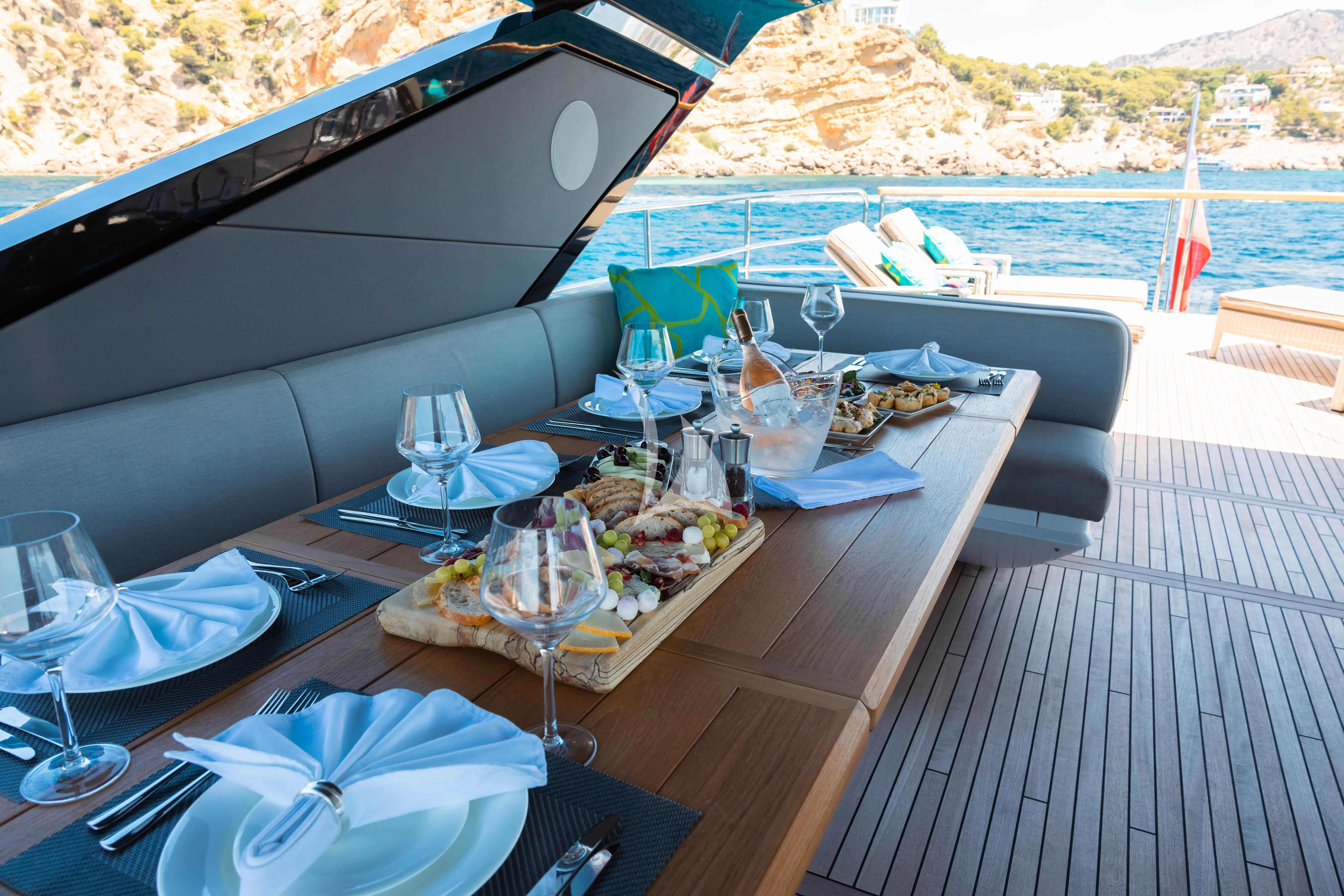a table with food and wine glasses on it aboard MOONLIGHT Yacht for Sale