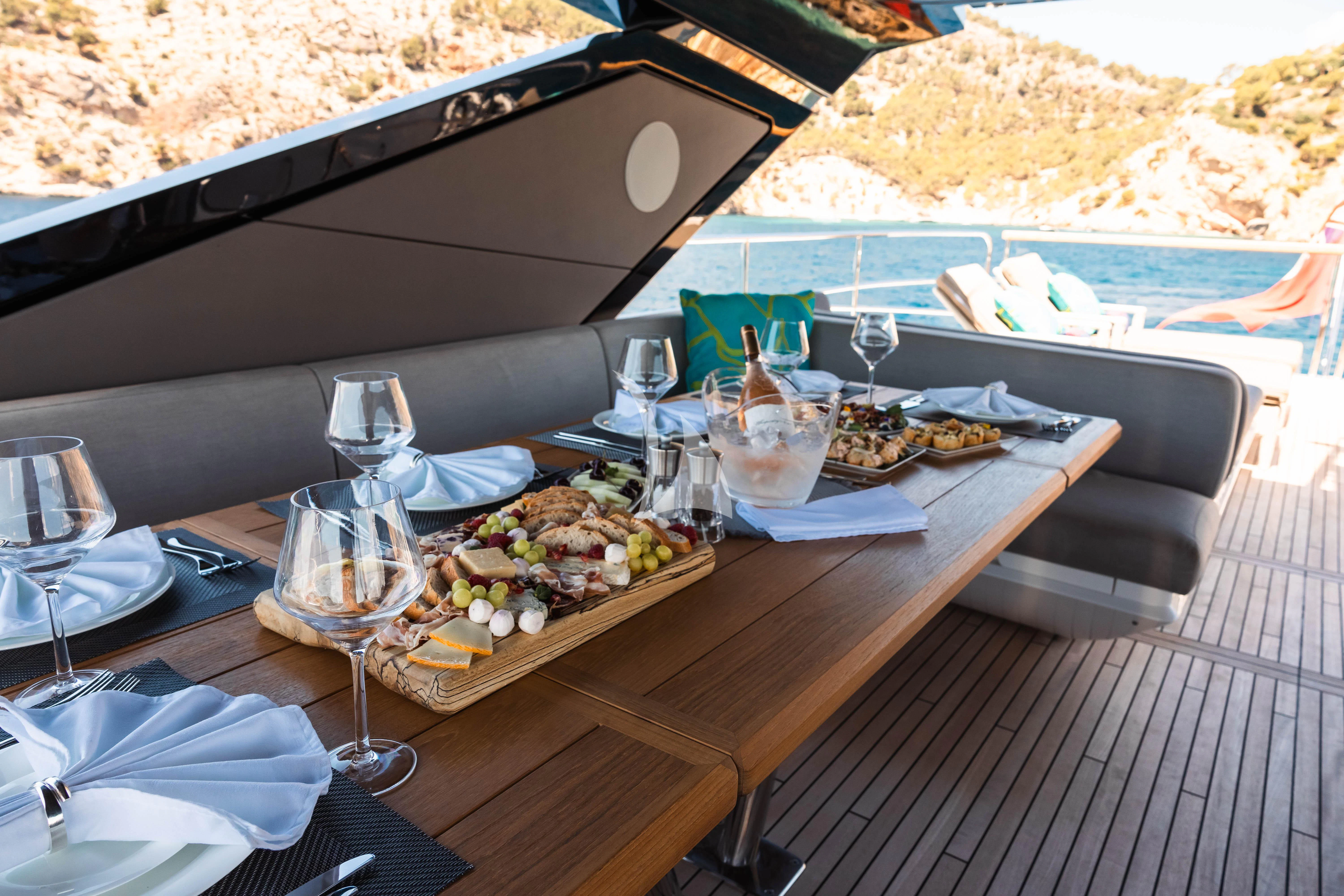 a table with food and glasses on it aboard MOONLIGHT Yacht for Sale