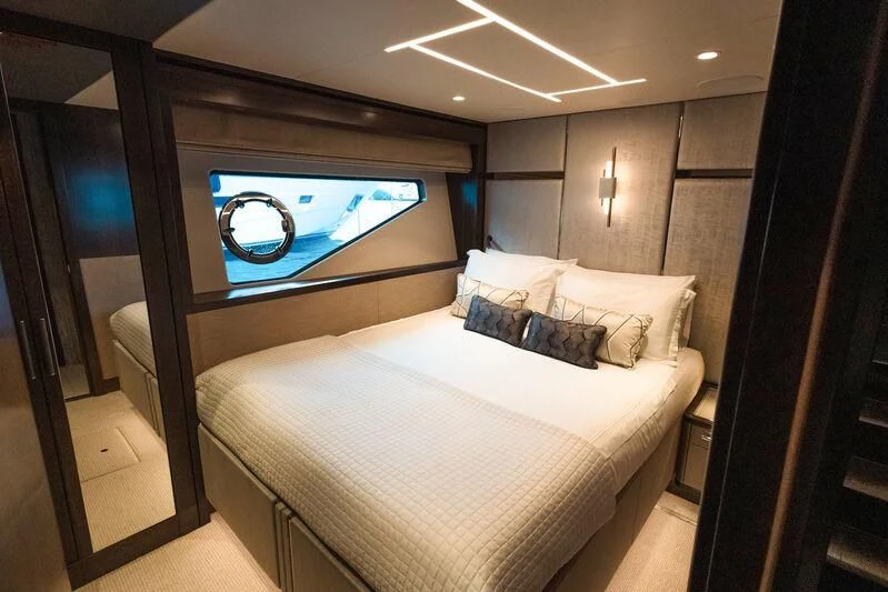 a bed with a white bed and a blue framed painting aboard MOONLIGHT Yacht for Sale
