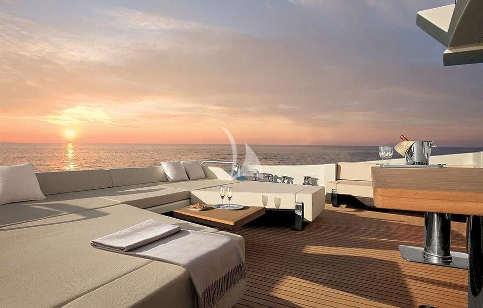 a room with a bed and a table with a view of the ocean aboard DUKE Yacht for Sale